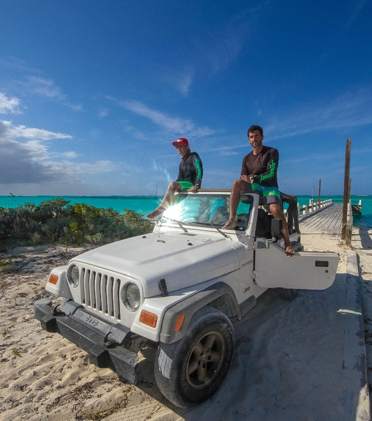 Two men sitting on top of Jeep